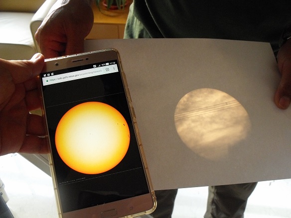 落日時分解說老師抓準角度， 在白紙上投射出太陽及太陽黑子的模樣 (國家公園電子報編輯小組提供)
