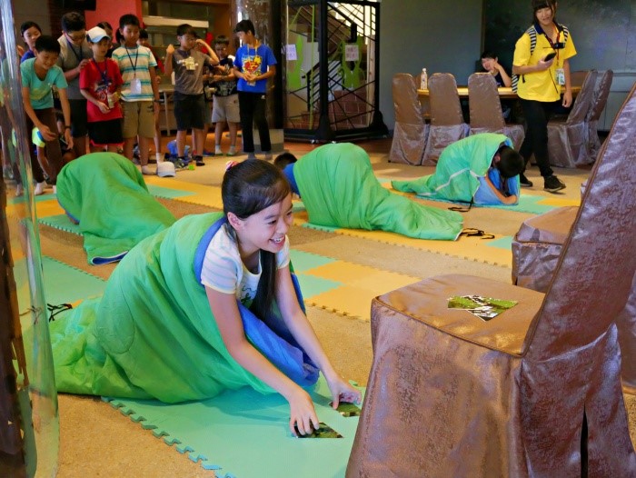 學員披上睡袋用手肘和腳著地， 模仿毛毛蟲行進模式  (國家公園電子報編輯小組提供)