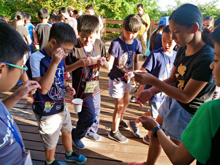 學員們同心協力運送水杯， 學習蜜蜂們的合作取食  (國家公園電子報編輯小組提供)