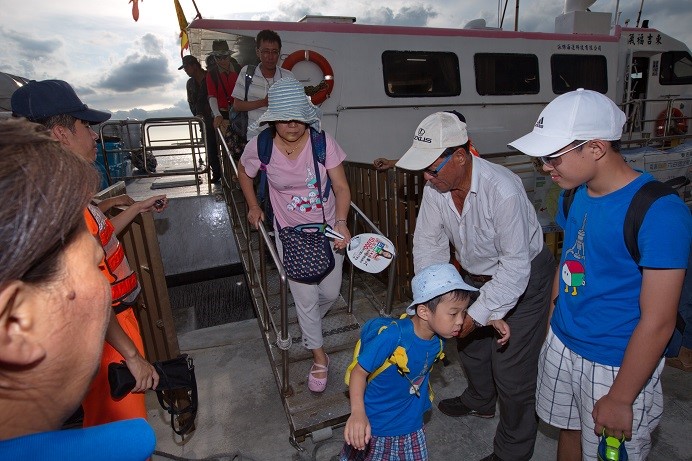 海管處為高齡長輩及年幼孩童著想， 貼心安排志工協助上下船 (海洋國家公園管理處提供)